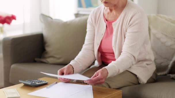 Senior vrouw met geld en papieren thuis — Stockvideo