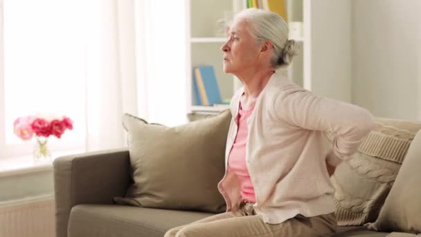 Senior woman suffering from pain in back at home — Stock Video