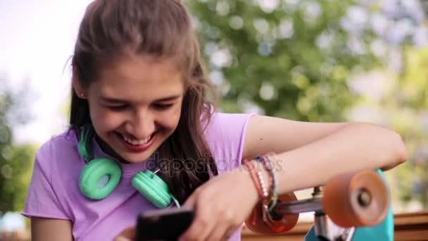 Adolescente feliz con smartphone y longboard — Vídeos de Stock