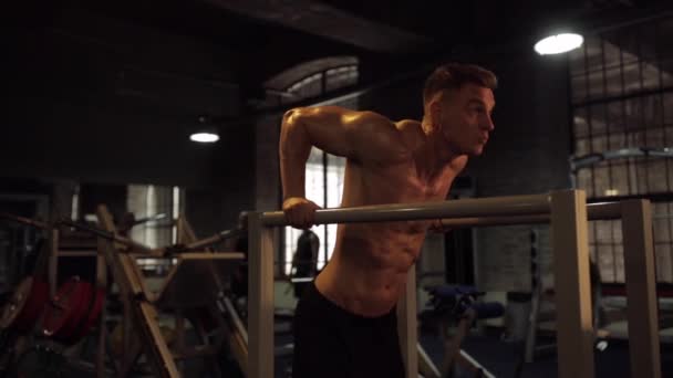 Man gör triceps dip på parallella barer i gymmet — Stockvideo