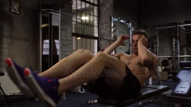 Jongeman sit-up abdominale oefeningen in de sportschool doet — Stockvideo