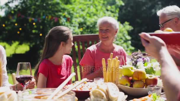 Счастливая семья с ужином или вечеринкой в летнем саду — стоковое видео