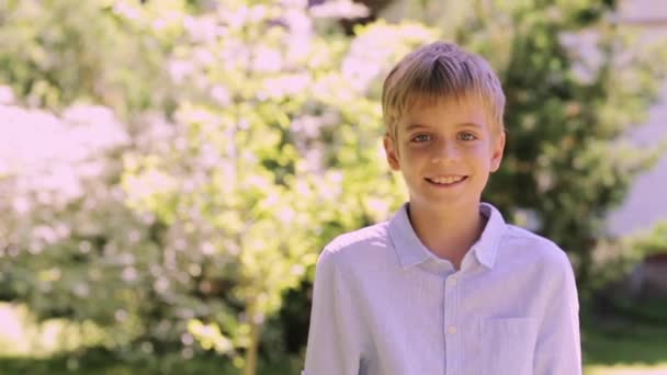 Glimlachend preteen jongen buitenshuis op zomertuin — Stockvideo