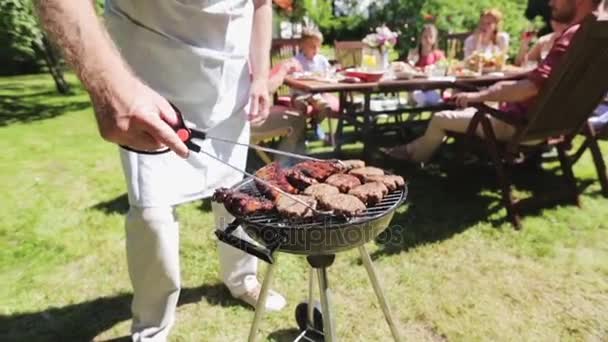 Hombre cocinar carne en barbacoa parrilla en la fiesta de verano — Vídeos de Stock