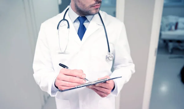 Close up of doctor with clipboard at hospital — Stock Photo, Image