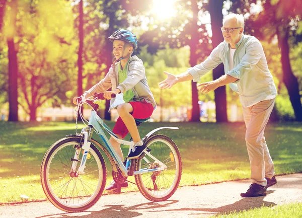 祖父和在夏天公园自行车的男孩 — 图库照片