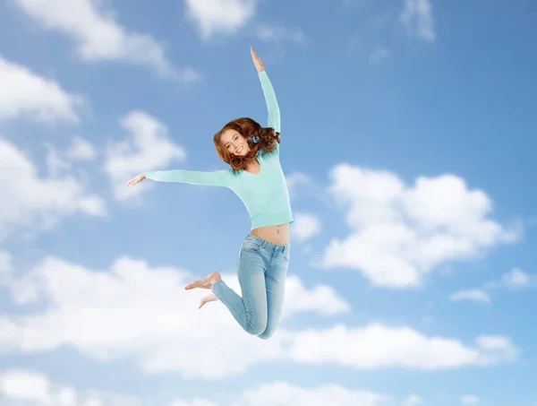 Sorrindo jovem mulher pulando no ar sobre o céu azul — Fotografia de Stock