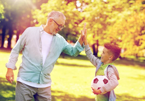 Viejo hombre y niño con pelota de fútbol haciendo cinco —  Fotos de Stock