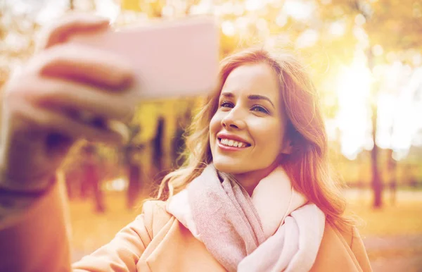 Mulher tomando selfie por smartphone no parque de outono — Fotografia de Stock