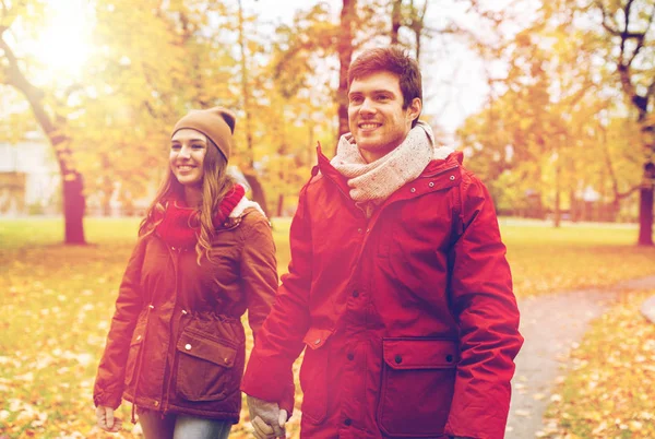 Happy young couple walking in autumn park — Stock Photo, Image