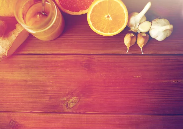 Madu, jeruk buah, jahe dan bawang putih di atas kayu — Stok Foto