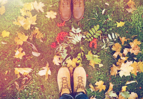 Πόδια σε μπότες με βατόμουρα και φθινοπωρινά φύλλα — Φωτογραφία Αρχείου