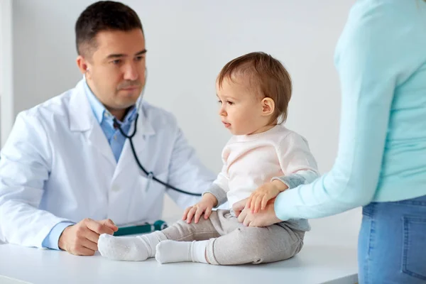 Mulher feliz com bebê e médico na clínica — Fotografia de Stock