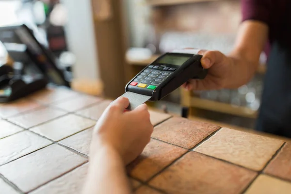 Mãos com terminal de pagamento e cartão de crédito — Fotografia de Stock