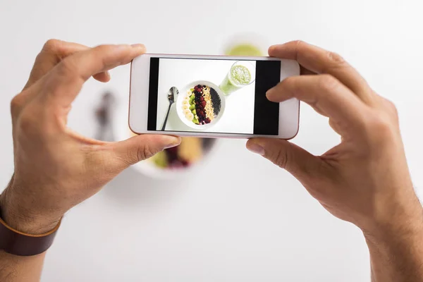 Hombre fotografiando desayuno saludable por teléfono inteligente — Foto de Stock