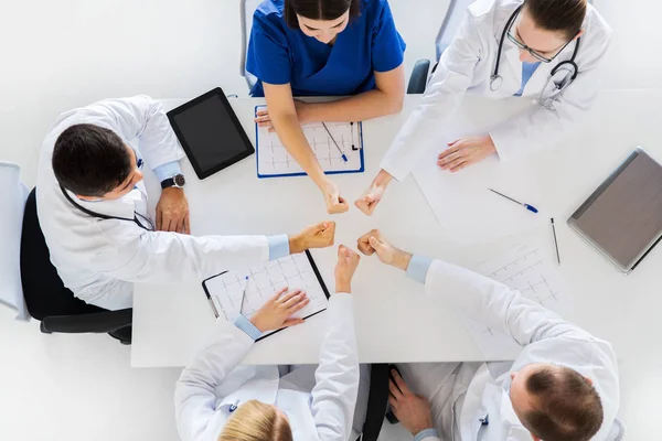 Skupina lékařů objevovat palce nad stůl — Stock fotografie