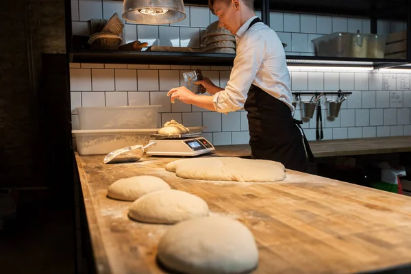 Chef o panadero que pesan masa a escala en la panadería —  Fotos de Stock