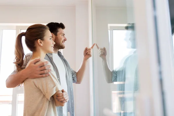 Couple heureux regardant par la fenêtre à la nouvelle maison — Photo