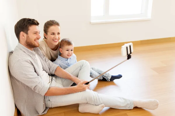 Familia tomando selfie por teléfono inteligente en un nuevo hogar — Foto de Stock