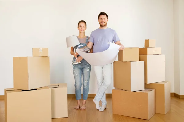 Pareja con cajas y plano de mudanza a nuevo hogar — Foto de Stock