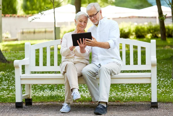 Gelukkige senior paar met de tablet pc in stadspark — Stockfoto