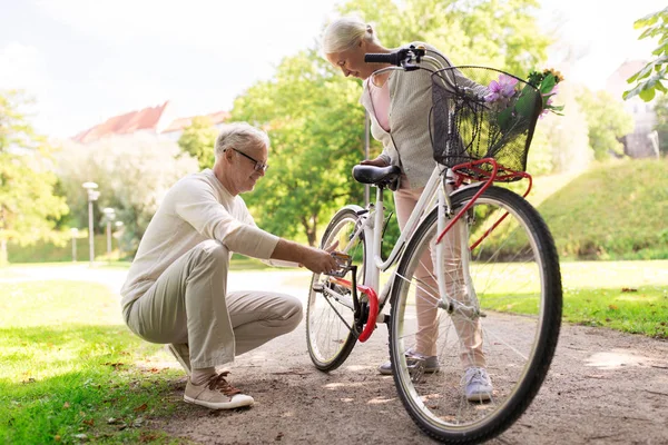 Щаслива старша пара з велосипедом в літньому парку — стокове фото