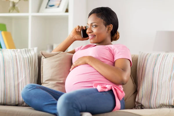 Heureuse femme enceinte appelant sur smartphone à la maison — Photo