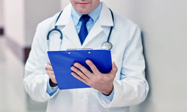 Close up of doctor with clipboard at hospital — Stock Photo, Image