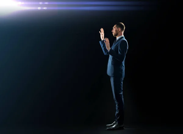 Businessman in suit touching something invisible — Stock Photo, Image