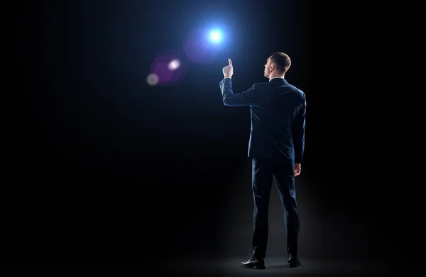 Businessman in suit pointing finger to lens flare — Stock Photo, Image