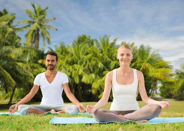 Pareja haciendo yoga en pose de loto al aire libre —  Fotos de Stock