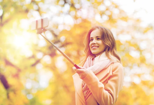 Kvinnan tar selfie av smartphone i höst park — Stockfoto