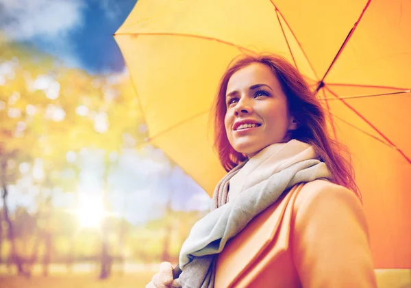 Happy woman with umbrella walking in autumn park — Stock Photo, Image