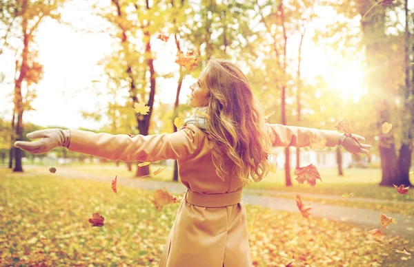 Femme heureuse s'amuser avec des feuilles dans le parc d'automne — Photo