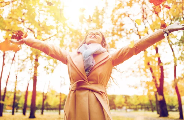 Femme heureuse s'amuser avec des feuilles dans le parc d'automne — Photo