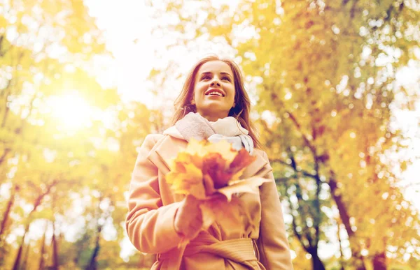 Hermosa mujer con hojas de arce en el parque de otoño —  Fotos de Stock