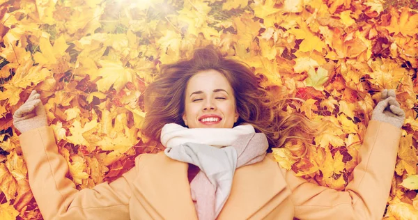 Bela mulher feliz deitada em folhas de outono — Fotografia de Stock