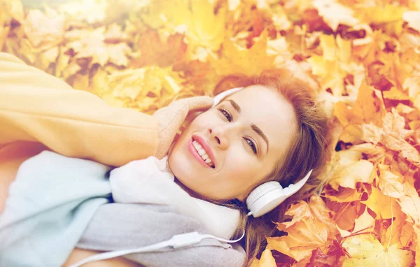 Mujer con auriculares escuchando música en otoño — Foto de Stock