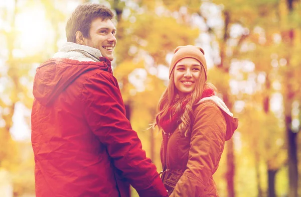 Feliz pareja joven caminando en el parque de otoño —  Fotos de Stock