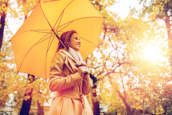 Mulher feliz com guarda-chuva andando no parque de outono Imagem De Stock