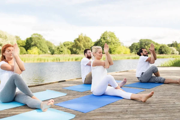 Mensen maken van yoga en mediteren buitenshuis — Stockfoto
