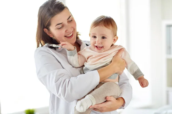 Doctor or pediatrician holding baby at clinic — Stock Photo, Image