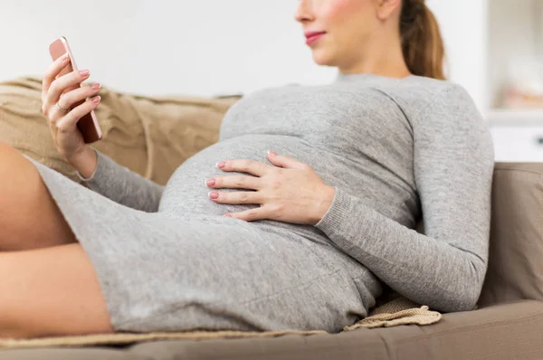 Mulher grávida feliz com smartphone em casa — Fotografia de Stock