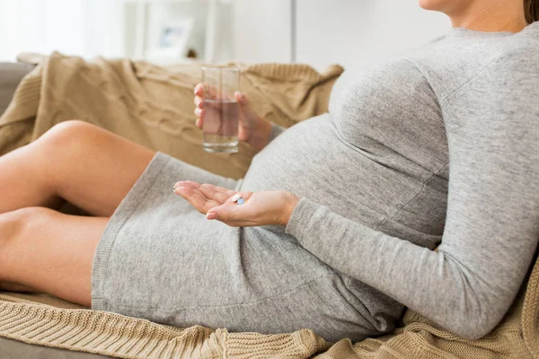 Close up of pregnant woman with pills at home — Stock Photo, Image