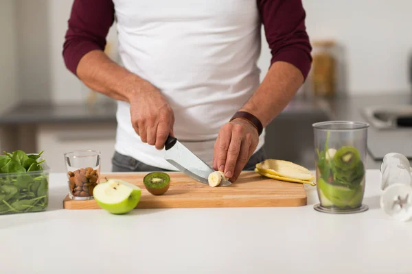 Pria dengan blender dan buah memasak di dapur rumah — Stok Foto