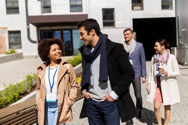 Mensen met koffie en conferentie badges in stad — Stockfoto