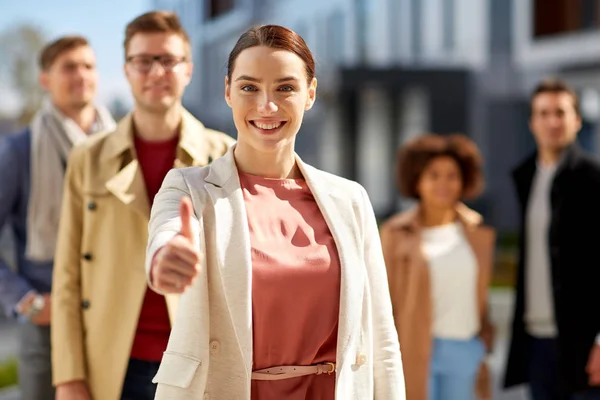 Gelukkig lachende vrouw weergegeven: duimschroef opwaarts buitenshuis — Stockfoto