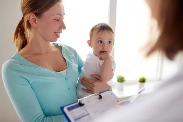 Happy woman with baby and doctor at clinic Stock Photo