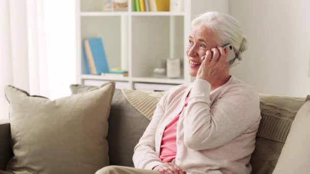 Seniorin mit Smartphone zu Hause telefonieren — Stockvideo