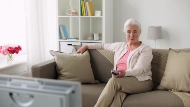 Счастливая пожилая женщина смотрит телевизор дома — стоковое видео